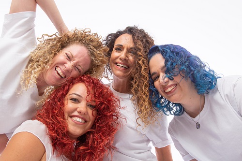 ארבע מתולתלות עם צבעי שיער שונים - בלונדיני, אדום, כחול ושטני