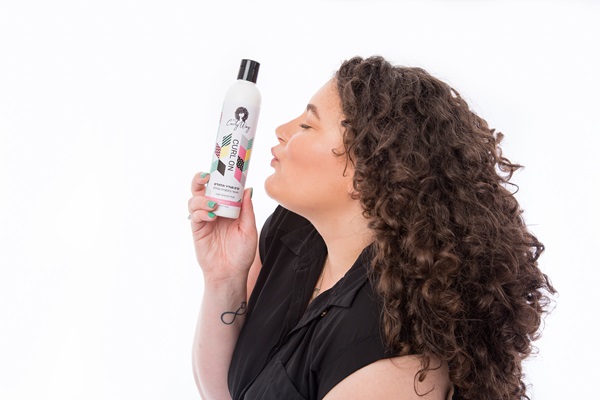 מתולתלת מרימה את קרם CURL ON ומנשקת אותו